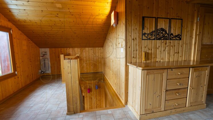 Holzvertäfelter Dachraum mit Treppe und eingebautem Sideboard