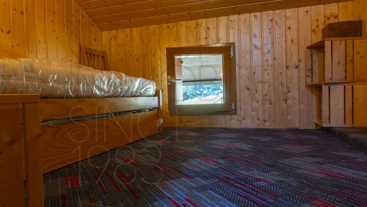 Holzverkleideter Schlafraum mit Teppichboden