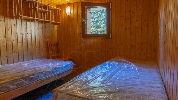 Holzverkleideter Schlafraum mit zwei Betten