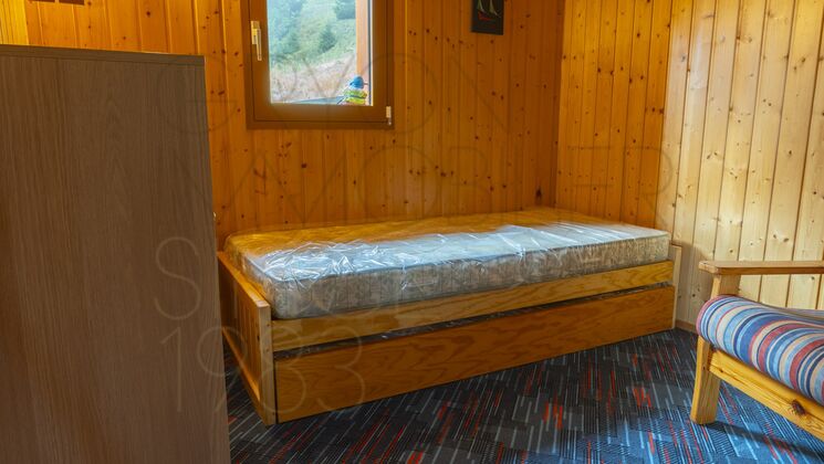 Holzverkleidetes Schlafzimmer mit Bett