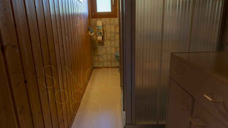Schmaler Badezimmerbereich mit Holzverkleidung