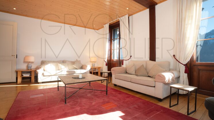 Helles Wohnzimmer mit zwei Sofas und Holzkassettendecke