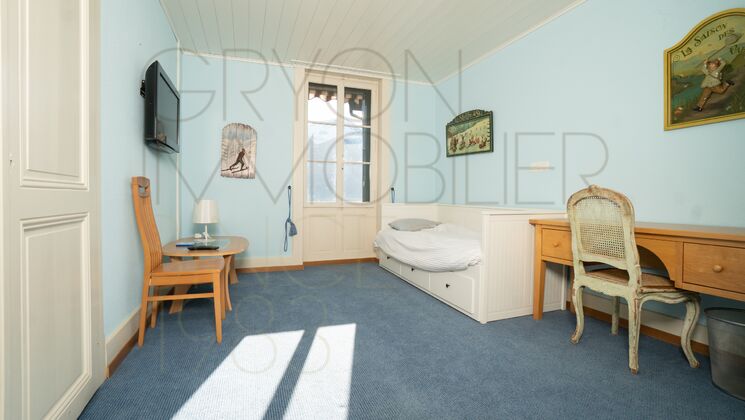 Helles Schlafzimmer mit blauem Teppich und antiken Möbeln