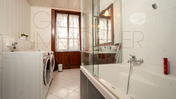 Badezimmer mit Badewanne und Waschmaschine