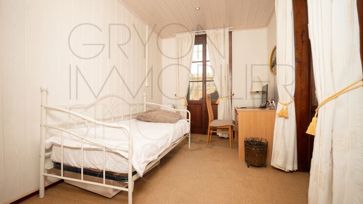 Helles Schlafzimmer mit Einzelbett und Holzkommode