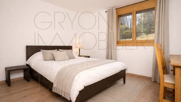 Schlafzimmer mit Doppelbett und Fensterblick