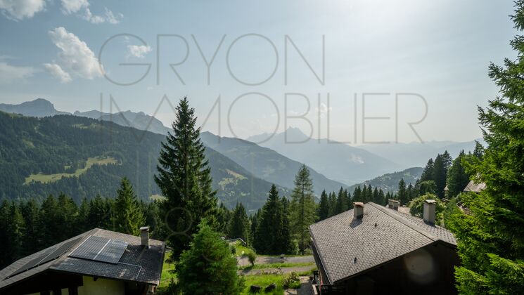Bergblick mit Chalets und Sonneneinstrahlung