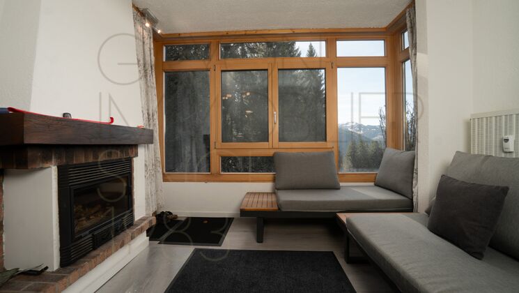 Wohnzimmer mit Kamin und großer Fensterfront