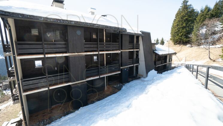 Schneebedecktes Holzchalet mit Balkonen
