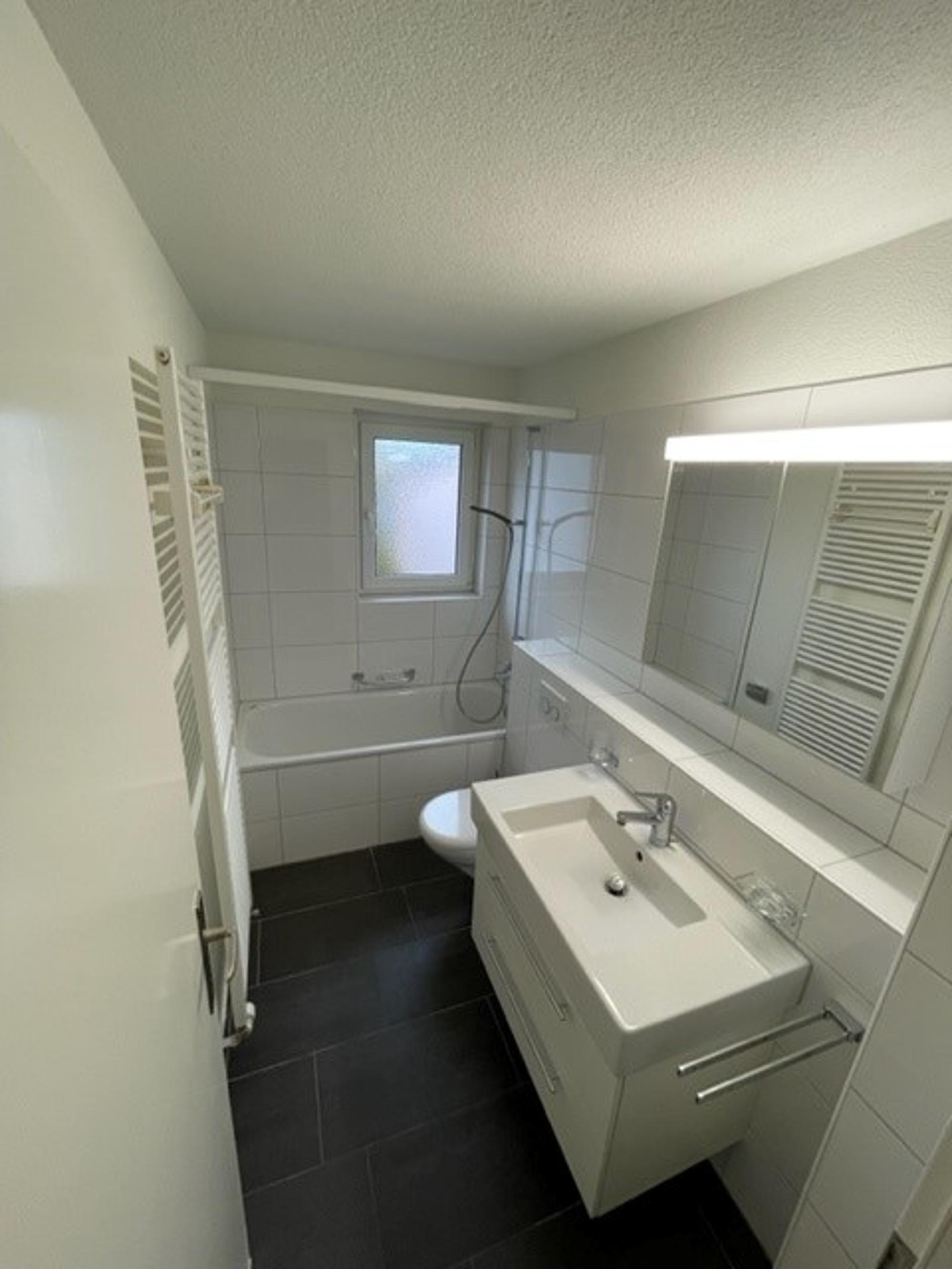 Kleines helles Badezimmer mit Wanne und Waschbecken