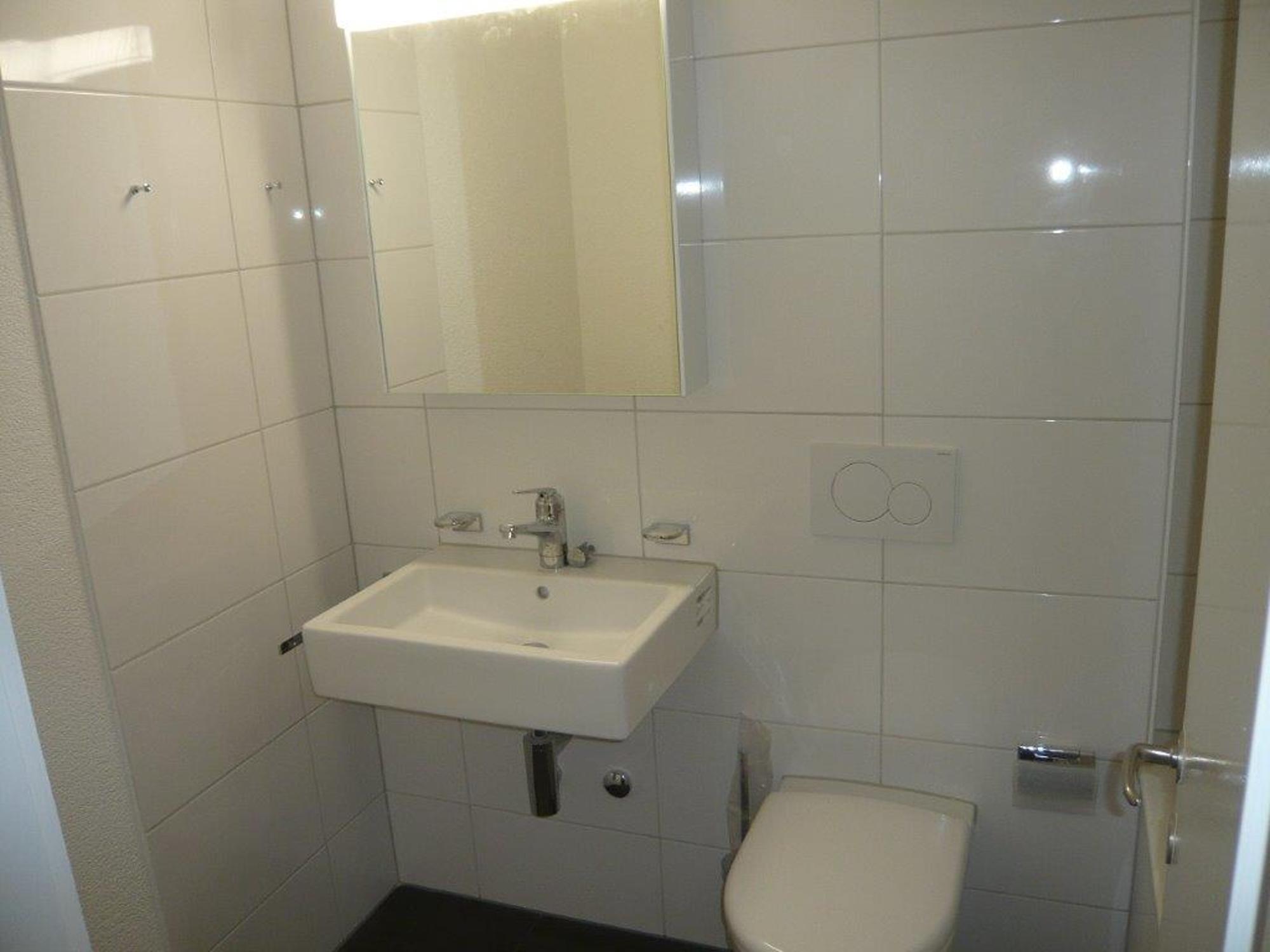 Gäste-WC mit Waschbecken und Toilette