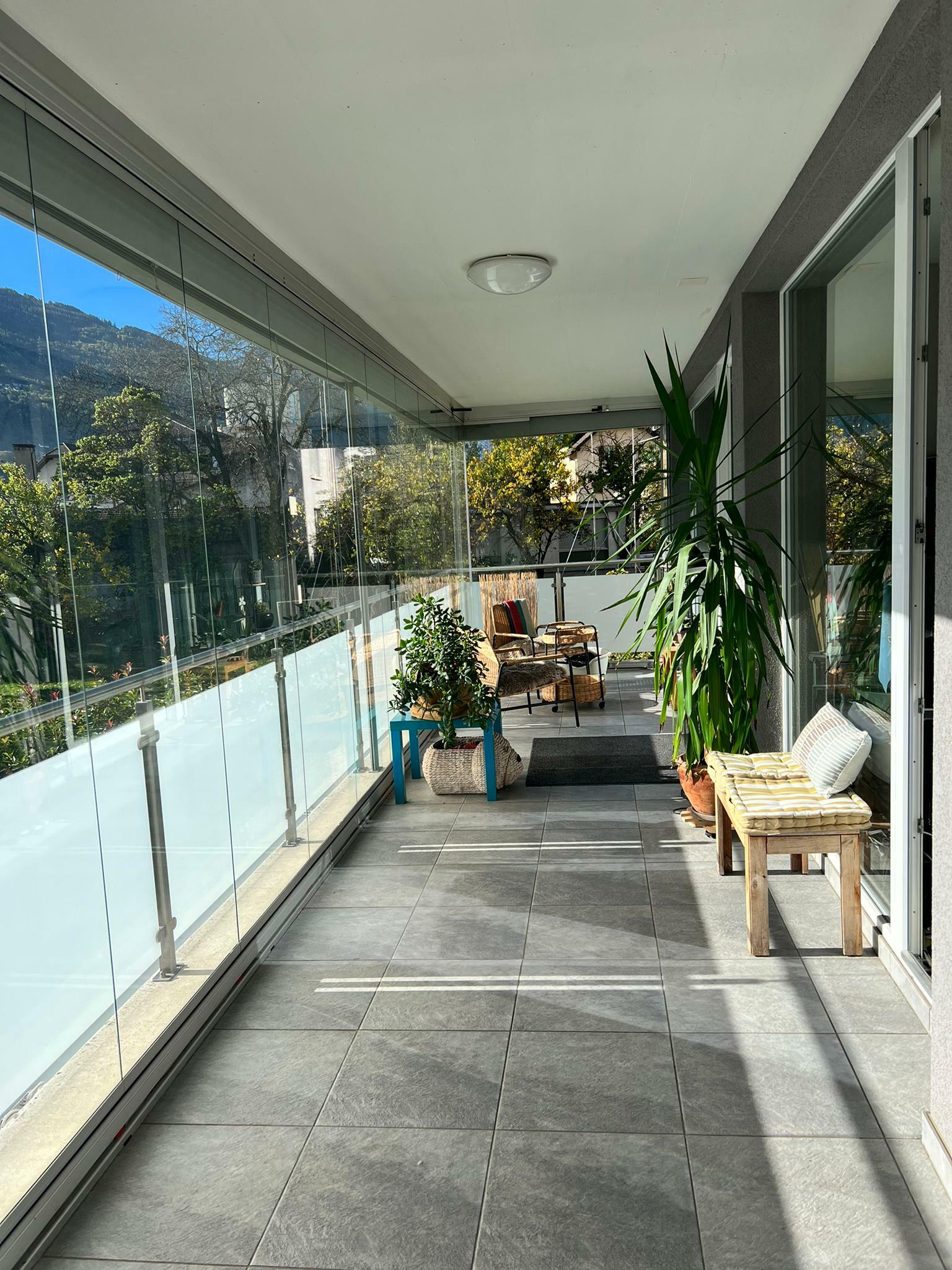 Überdachter Balkon mit Sitzgruppe
