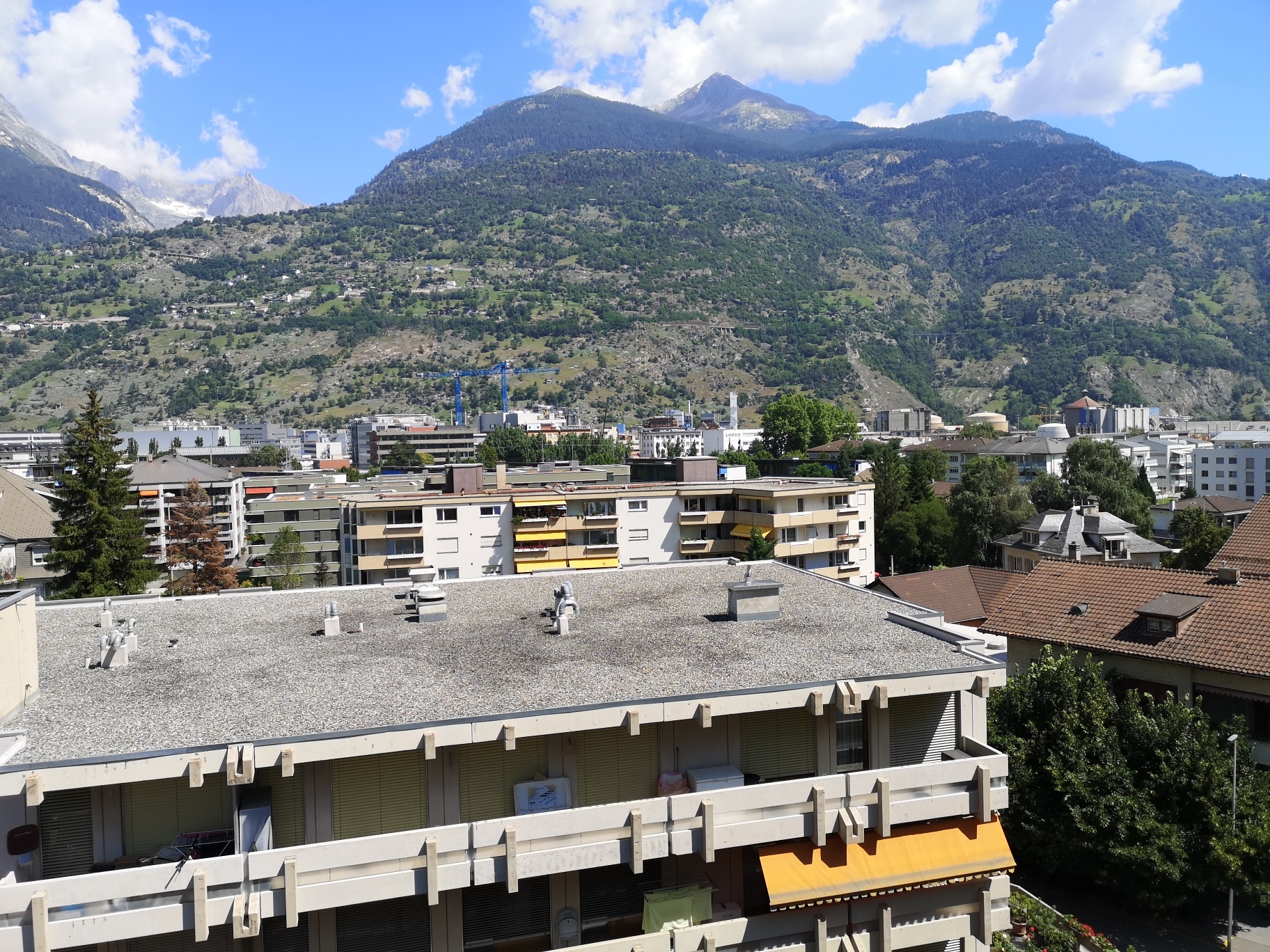 Stadt- und Bergblick von einem Flachdachgebäude