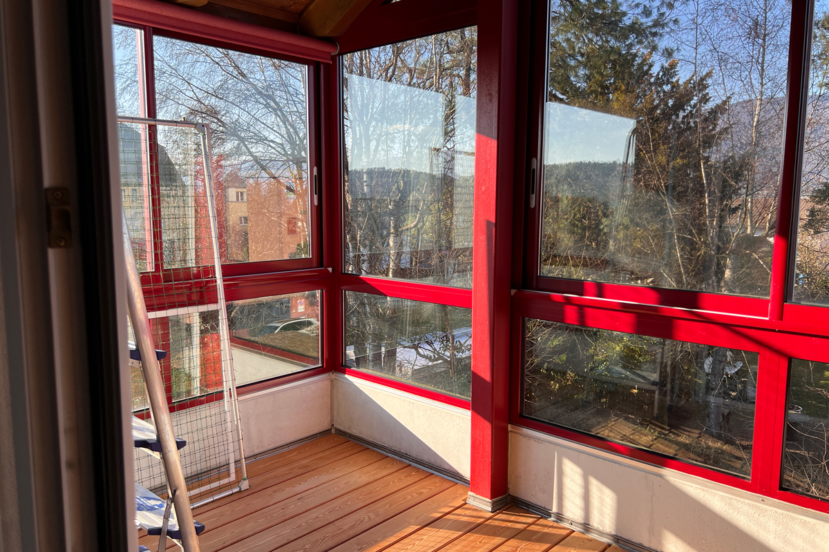 Verglaster Balkon mit rotem Rahmen