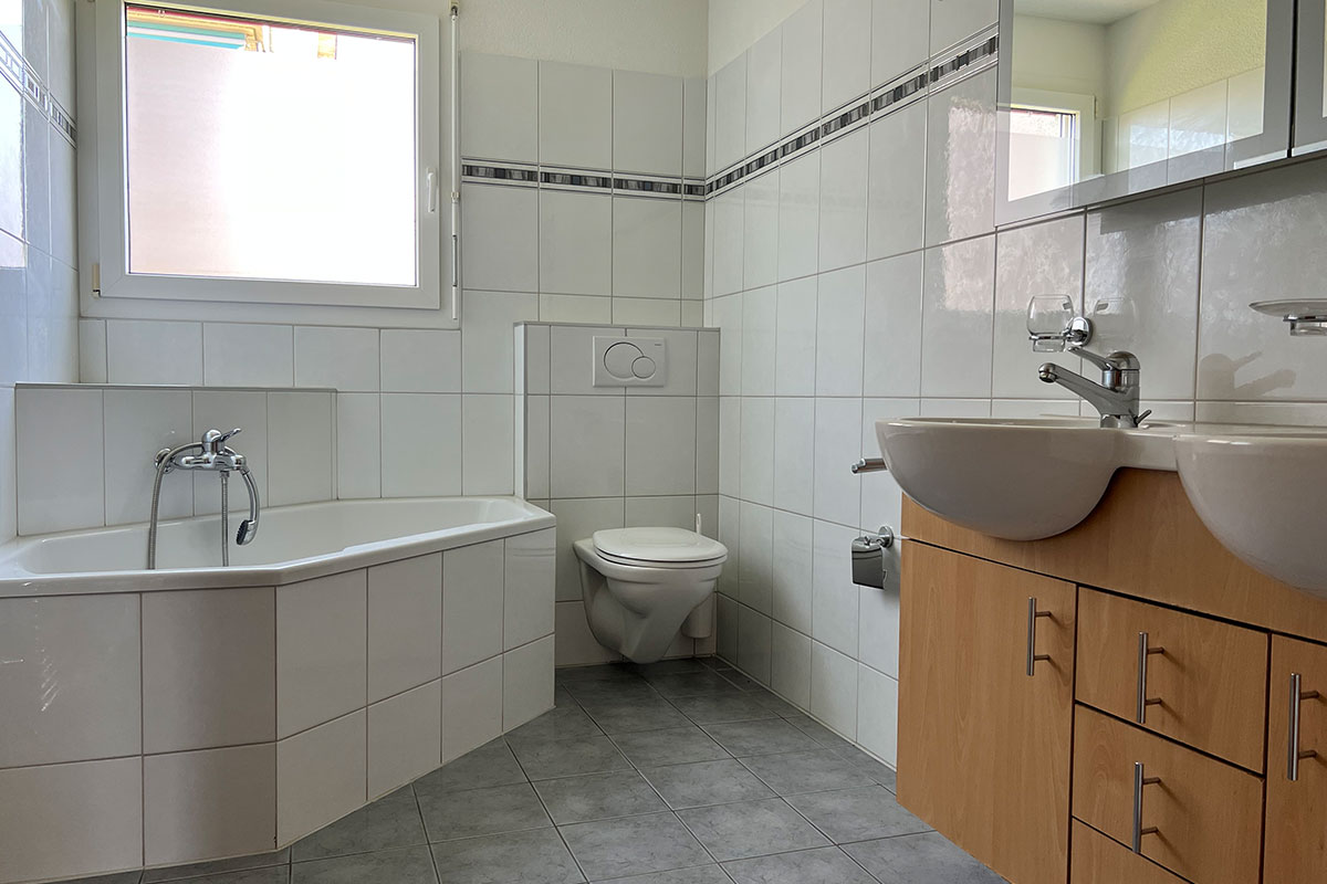 Badezimmer mit Badewanne und Doppelwaschbecken