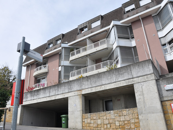 Wohnhaus mit Balkonen und Tiefgaragenzufahrt