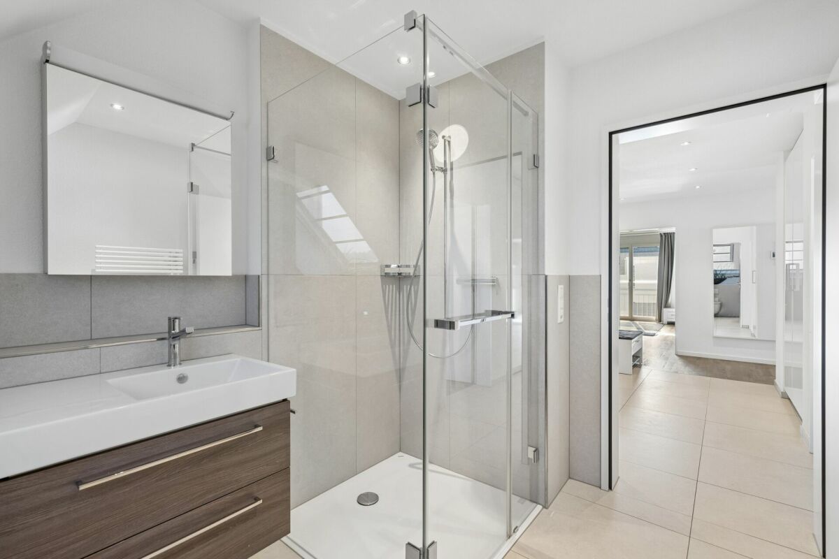 Modernes Badezimmer mit Dusche und Flurblick