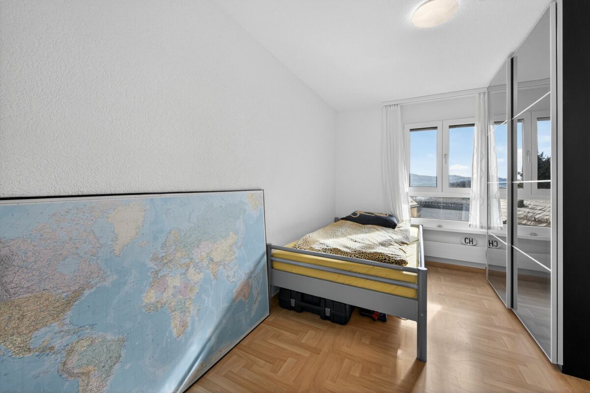 Kleines helles Schlafzimmer mit Einzelbett und Kleiderschrank