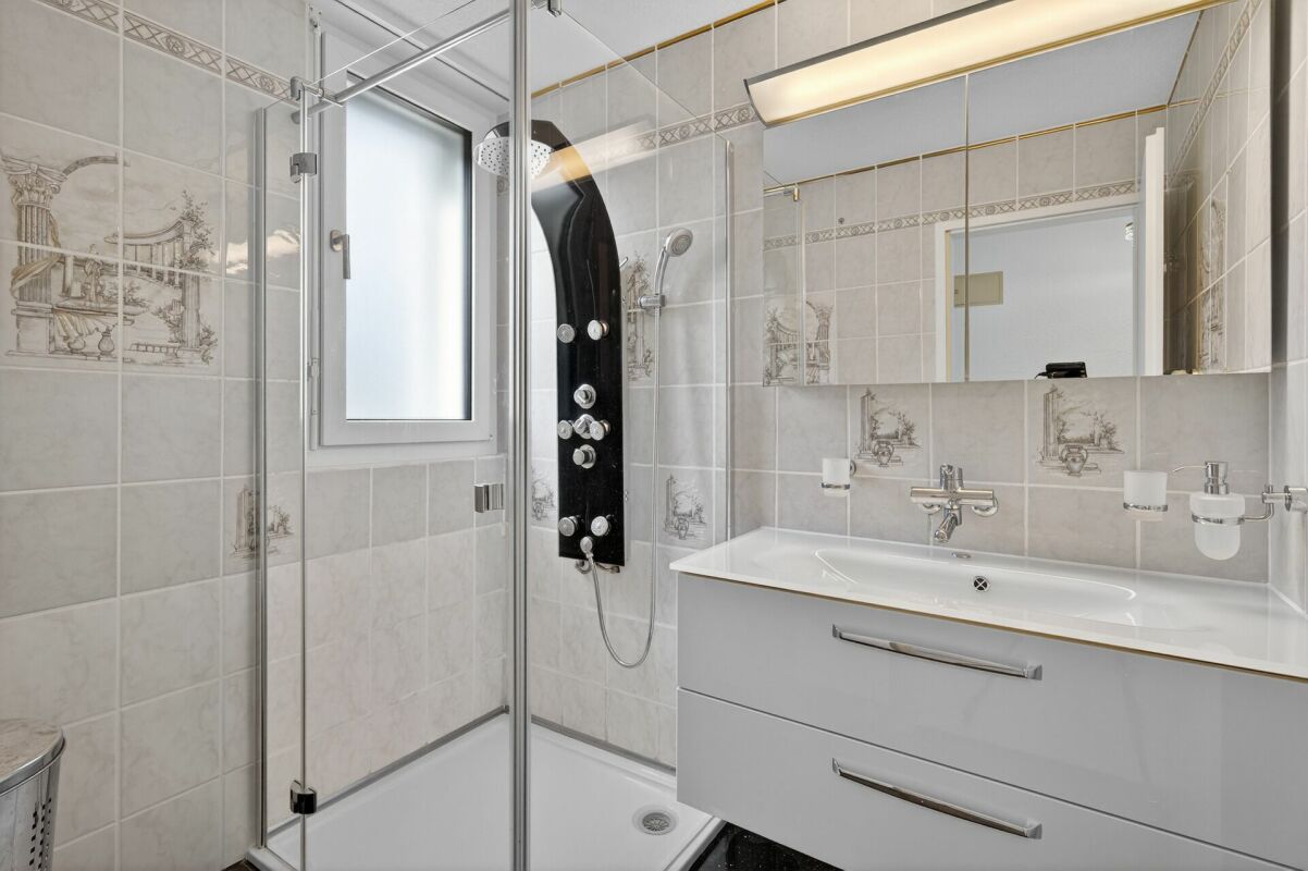 Modernes Badezimmer mit Glasdusche und Waschtisch