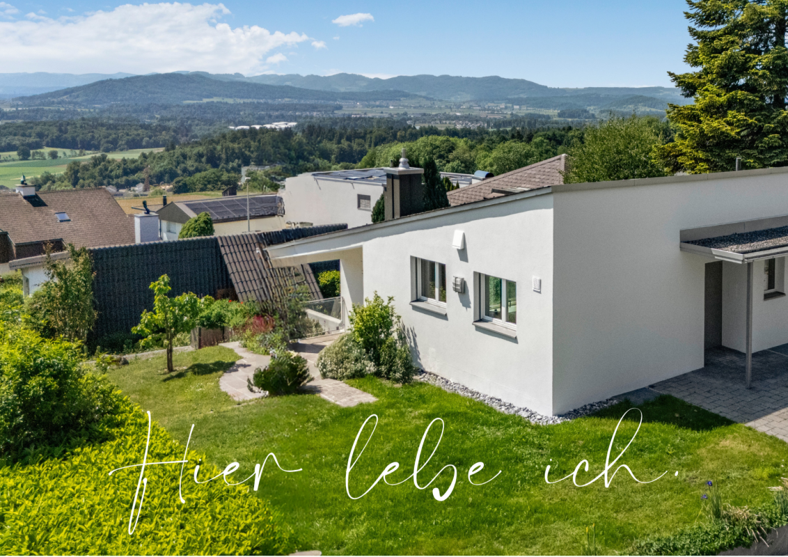 Außenansicht eines modernen Einfamilienhauses mit Garten und Alpenblick