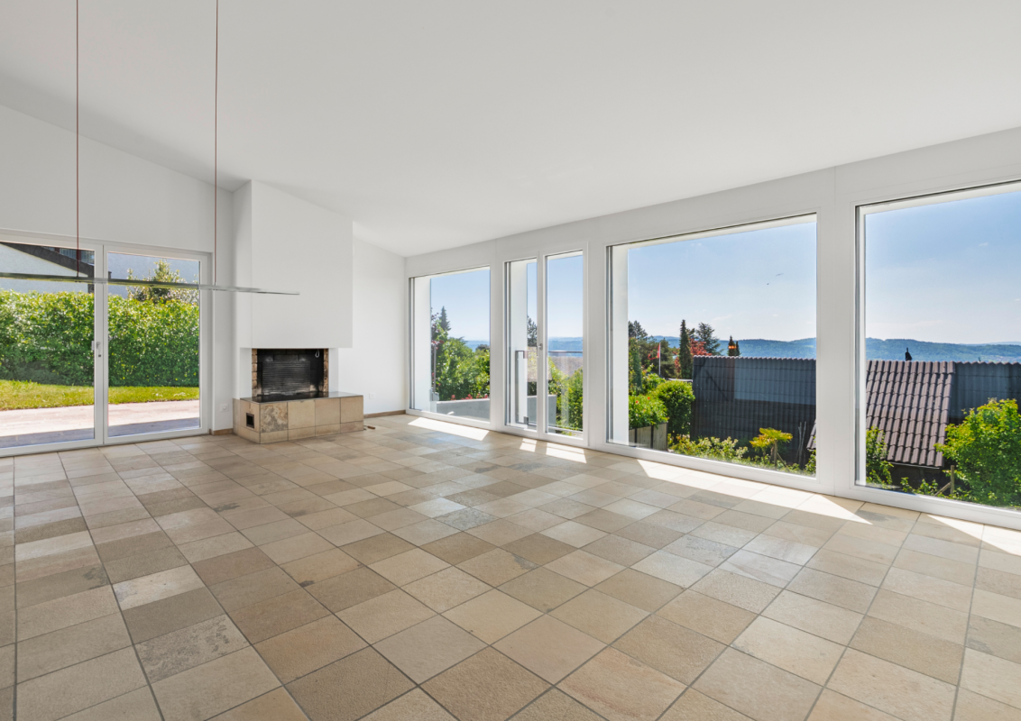 Heller Wohnraum mit Panoramafenstern und Kamin