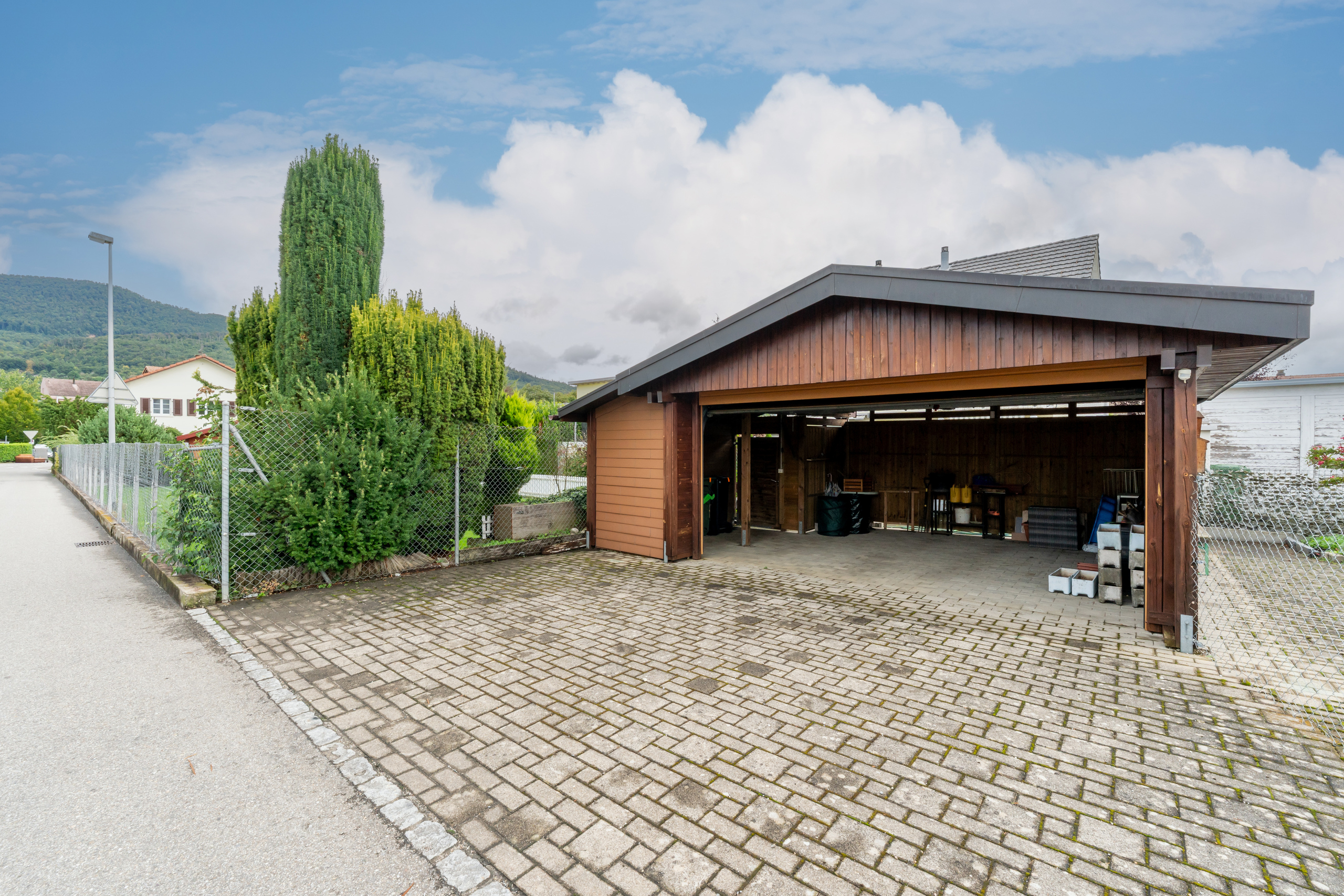 Carport mit gepflasterter Zufahrt