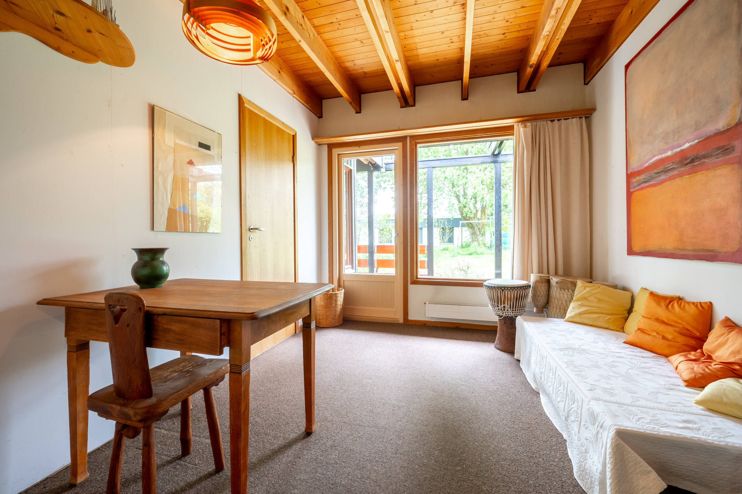 Helles Zimmer mit Holzbalkendecke und Sitzbereich