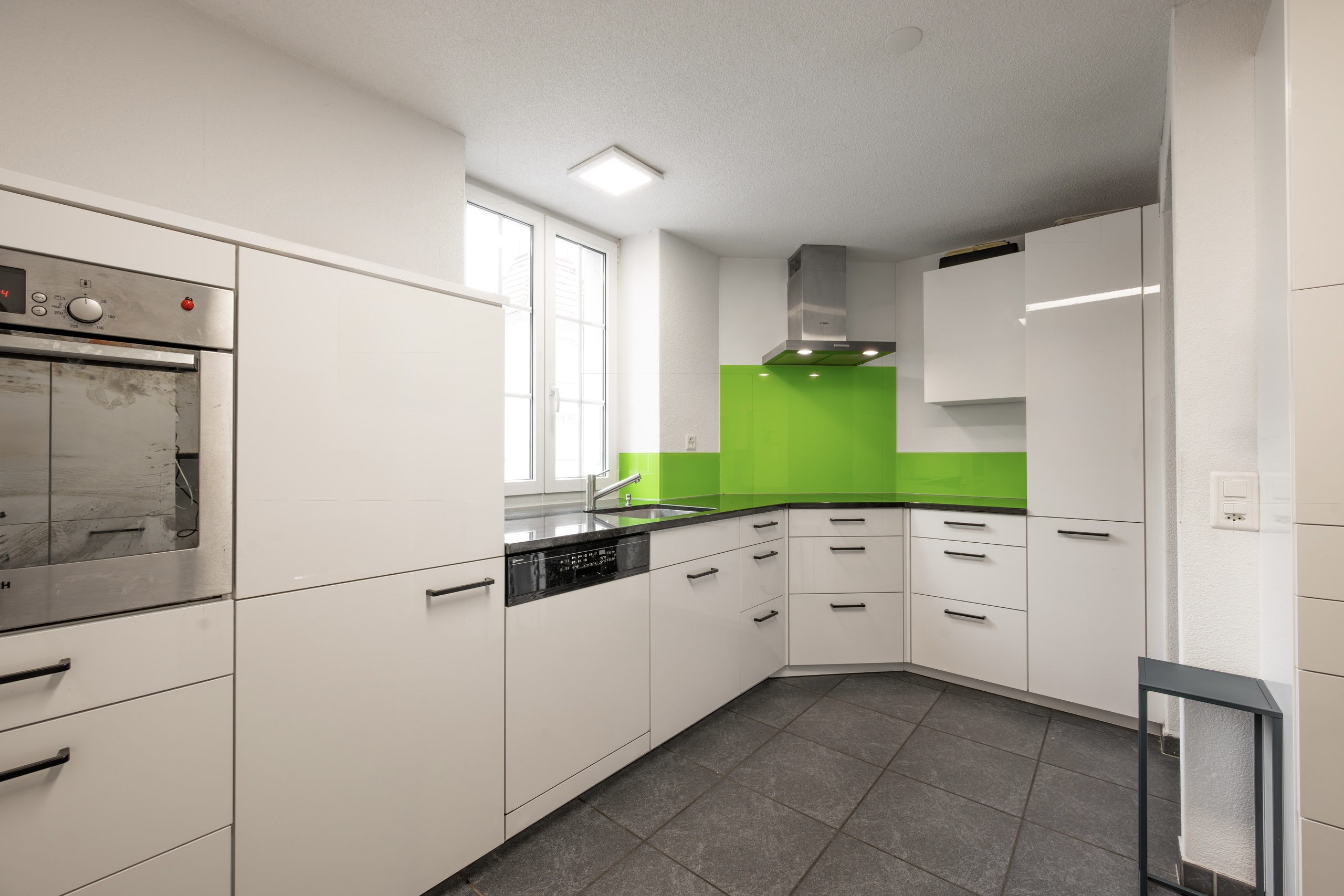 Moderne Einbauküche mit grüner Rückwand