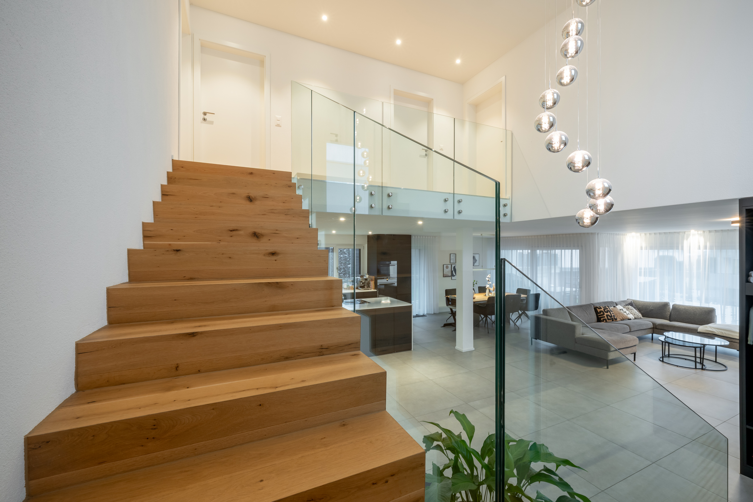 Moderner Wohnbereich mit Holztreppe und Glasgeländer