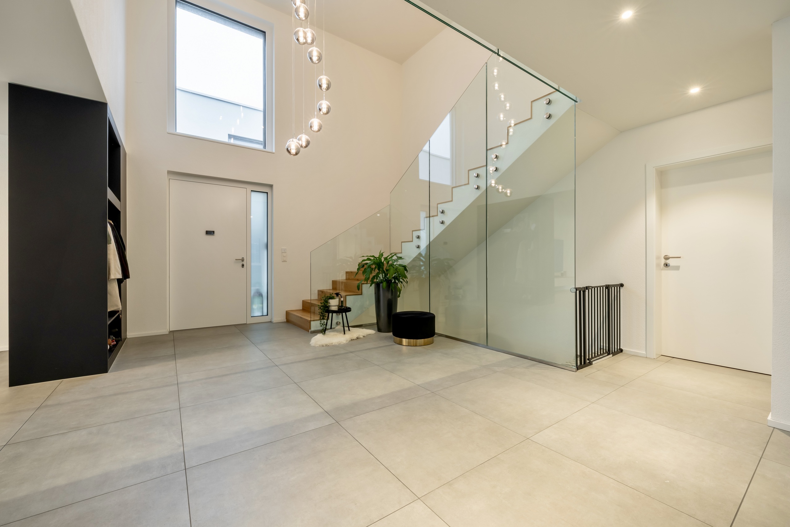 Moderner Eingangsbereich mit Glasgeländer und Treppe