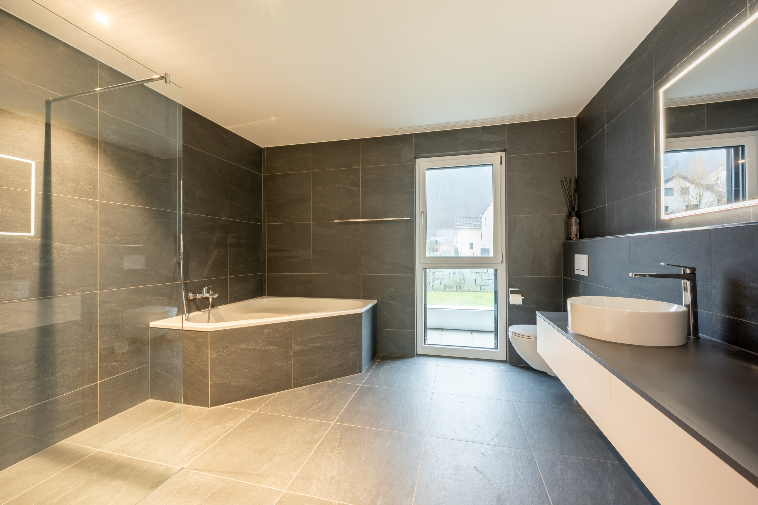 Modernes Badezimmer mit dunkler Natursteinoptik