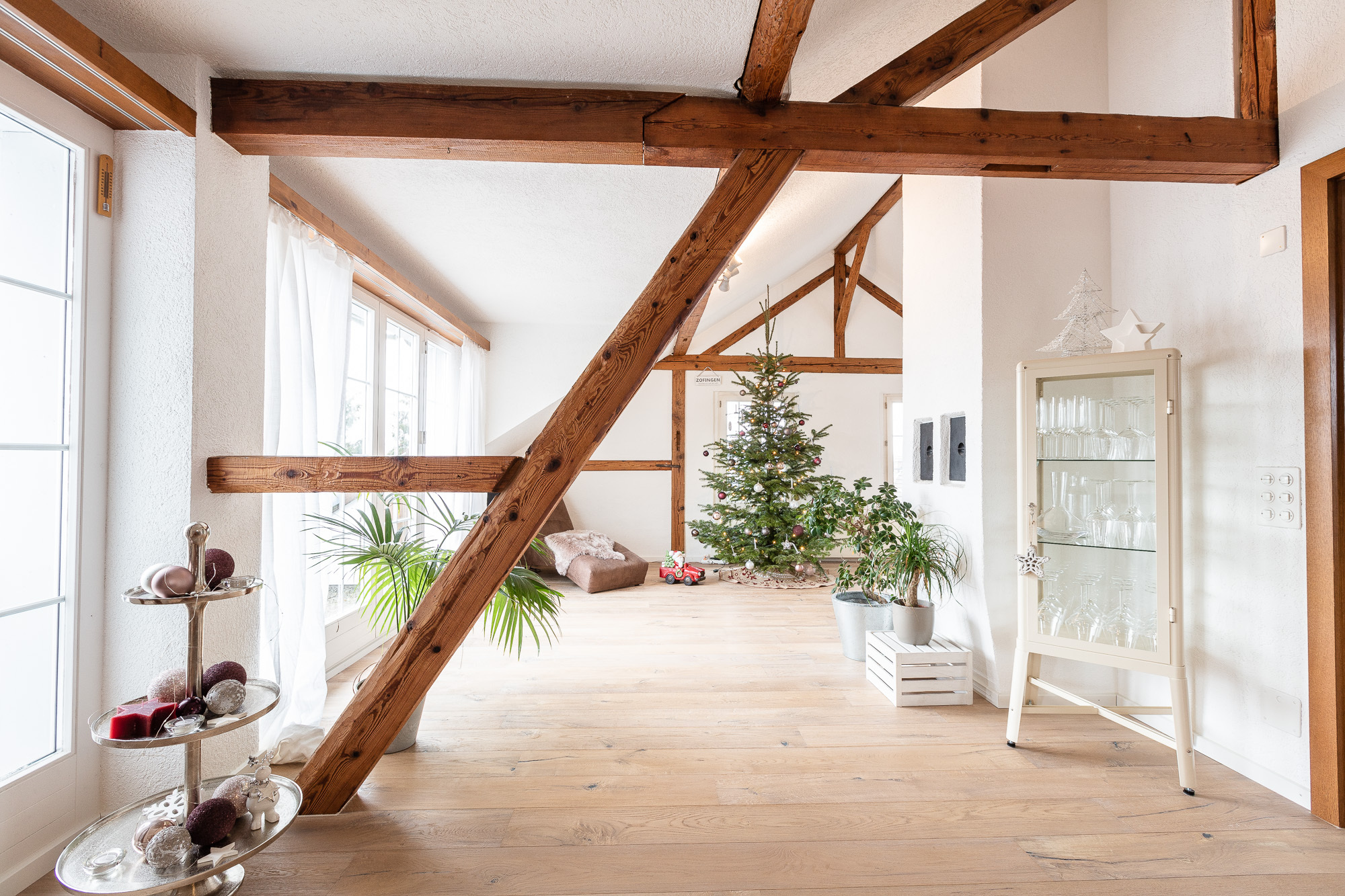 Heller Dachgeschoss-Wohnraum mit sichtbaren Holzbalken