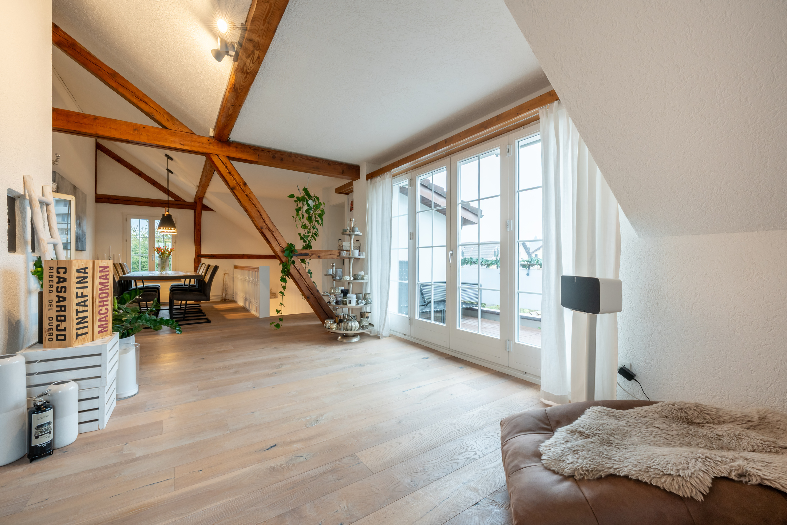 Heller Dachgeschoss-Wohnraum mit sichtbaren Holzbalken