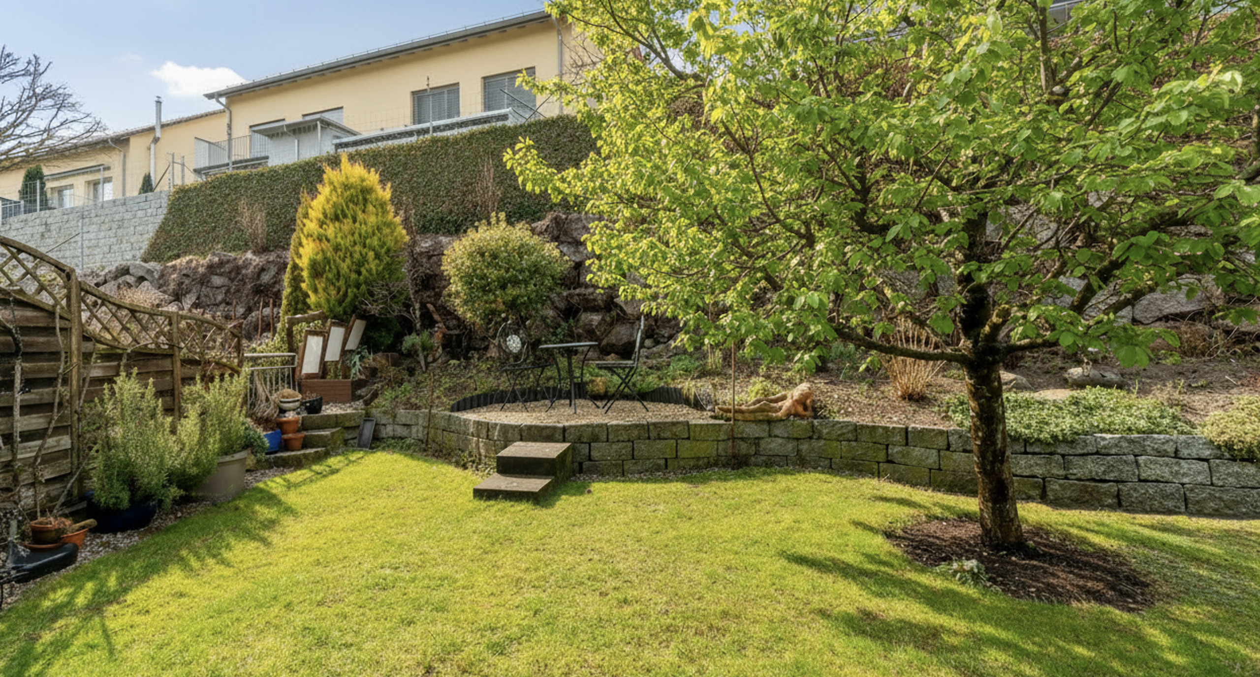 Großer gepflegter Garten mit Terrasse und Wohnhaus im Hintergrund