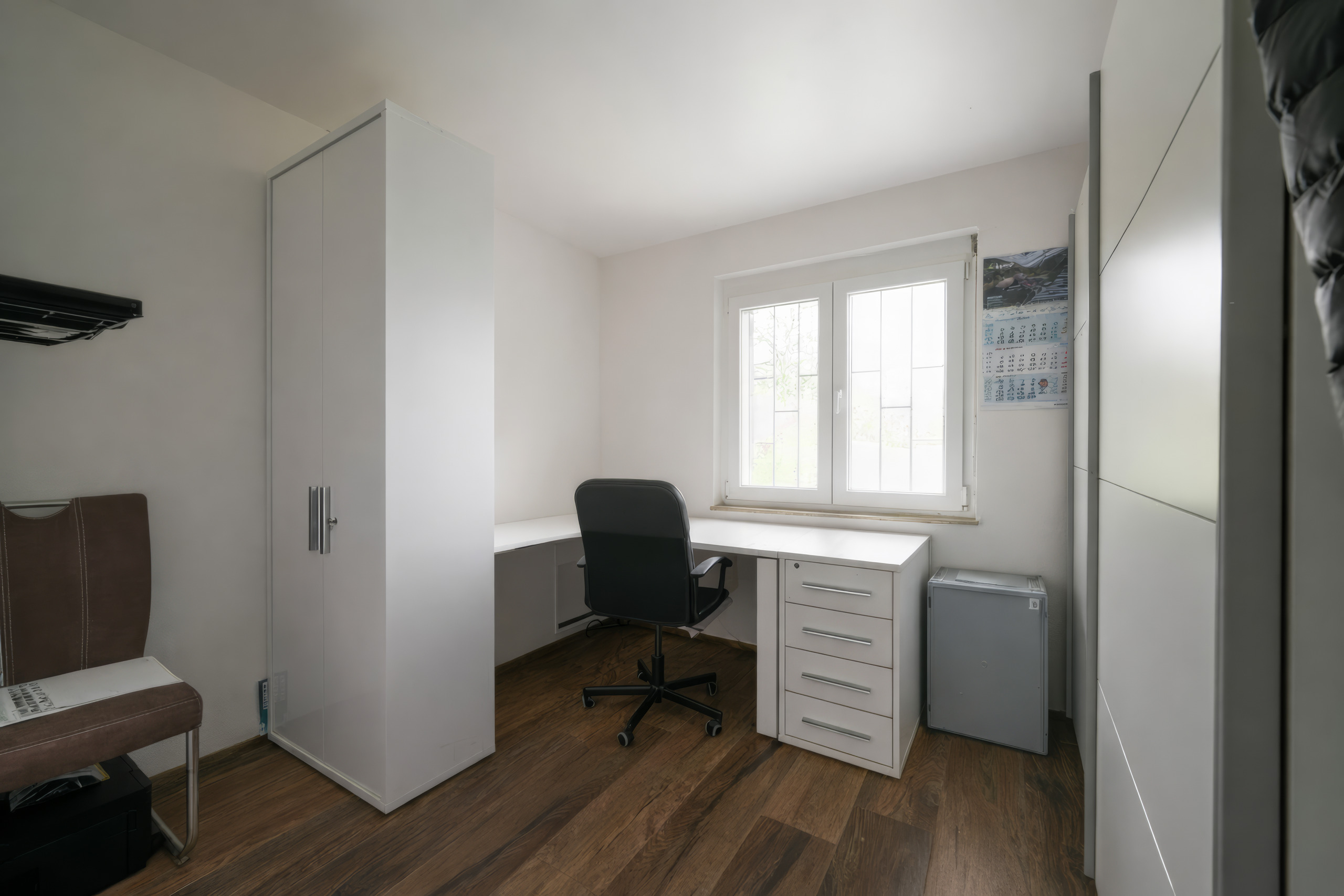 Helles Arbeitszimmer mit Schreibtisch und Schränken