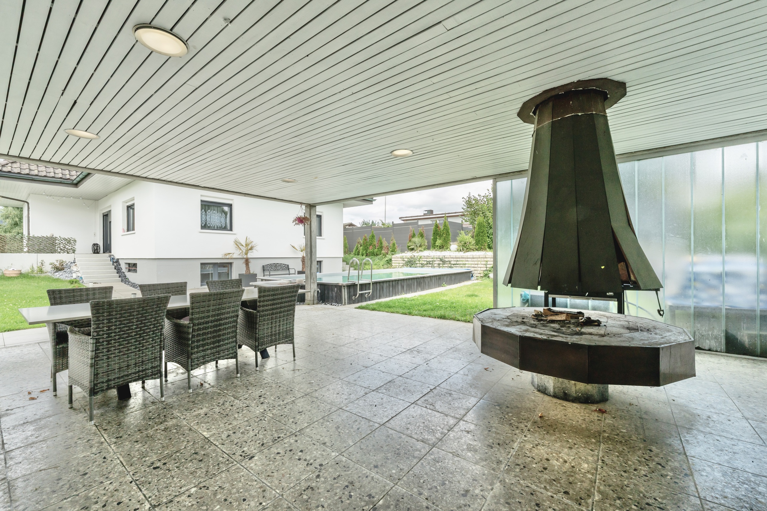 Überdachte Terrasse mit Feuerstelle und Essbereich