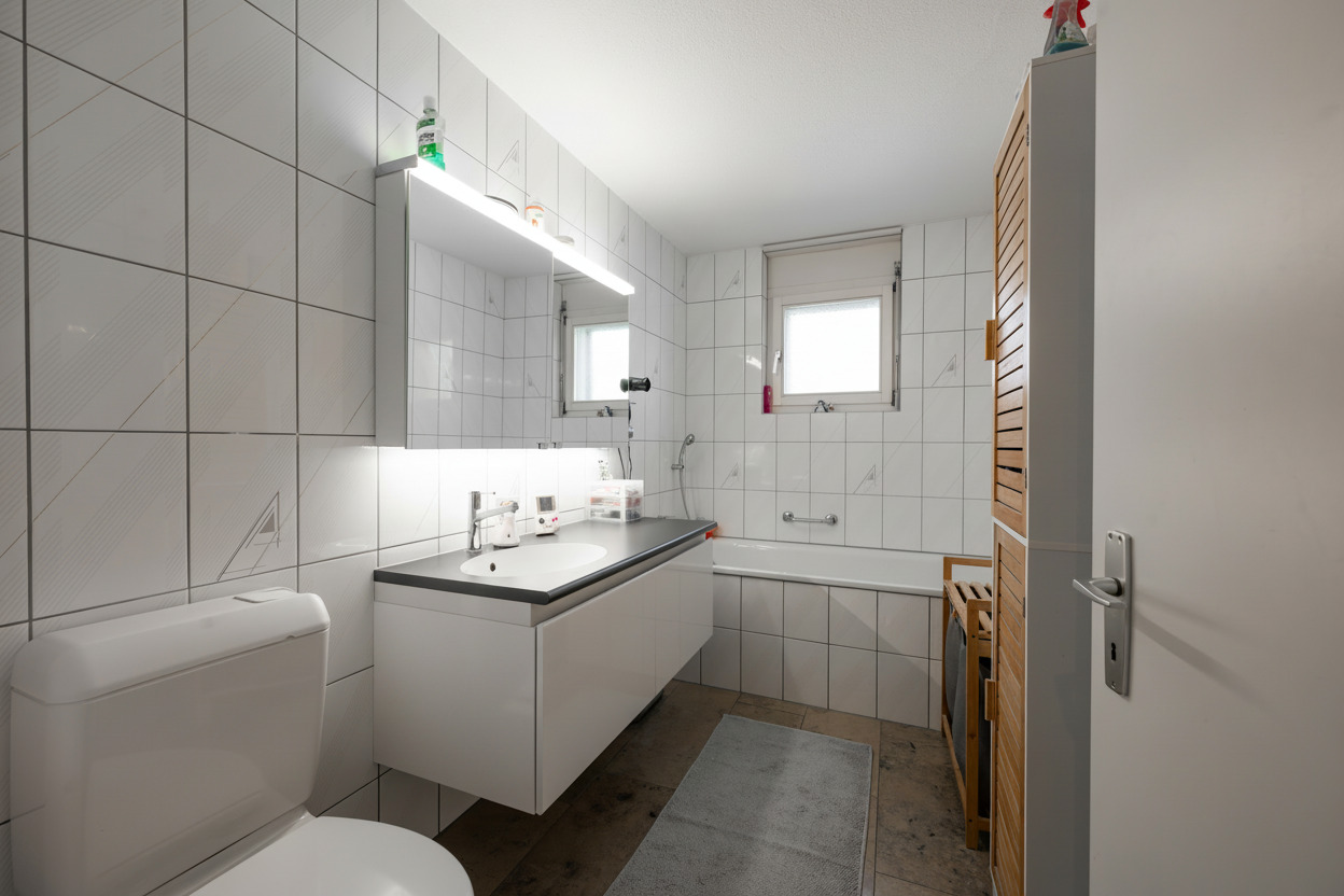 Helles Badezimmer mit Badewanne und Waschtisch
