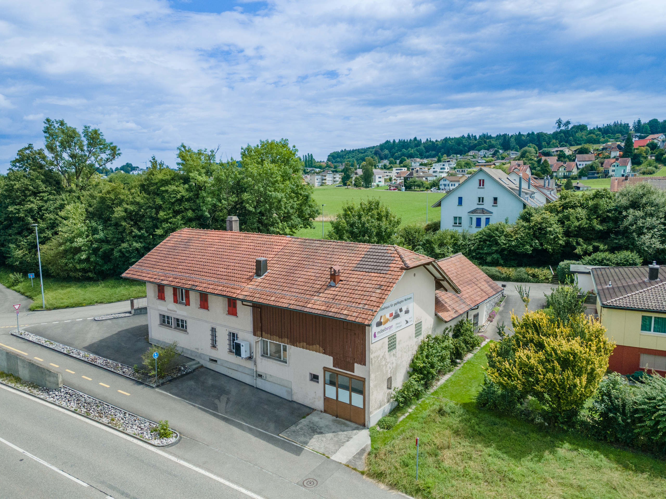 Luftaufnahme eines Wohngebiets mit Einfamilienhaus und Grünflächen