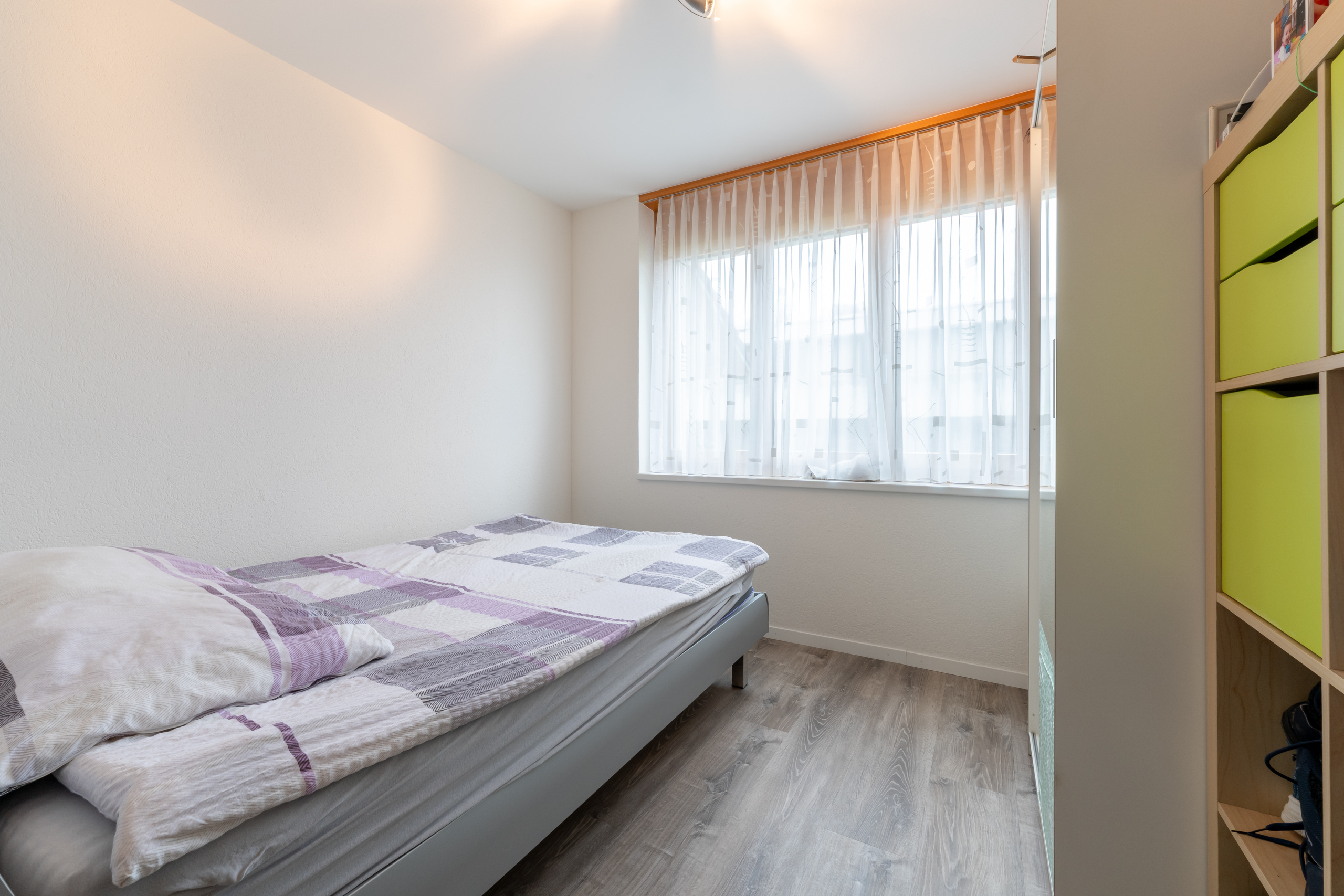Helles Schlafzimmer mit Einzelbett und Fenster