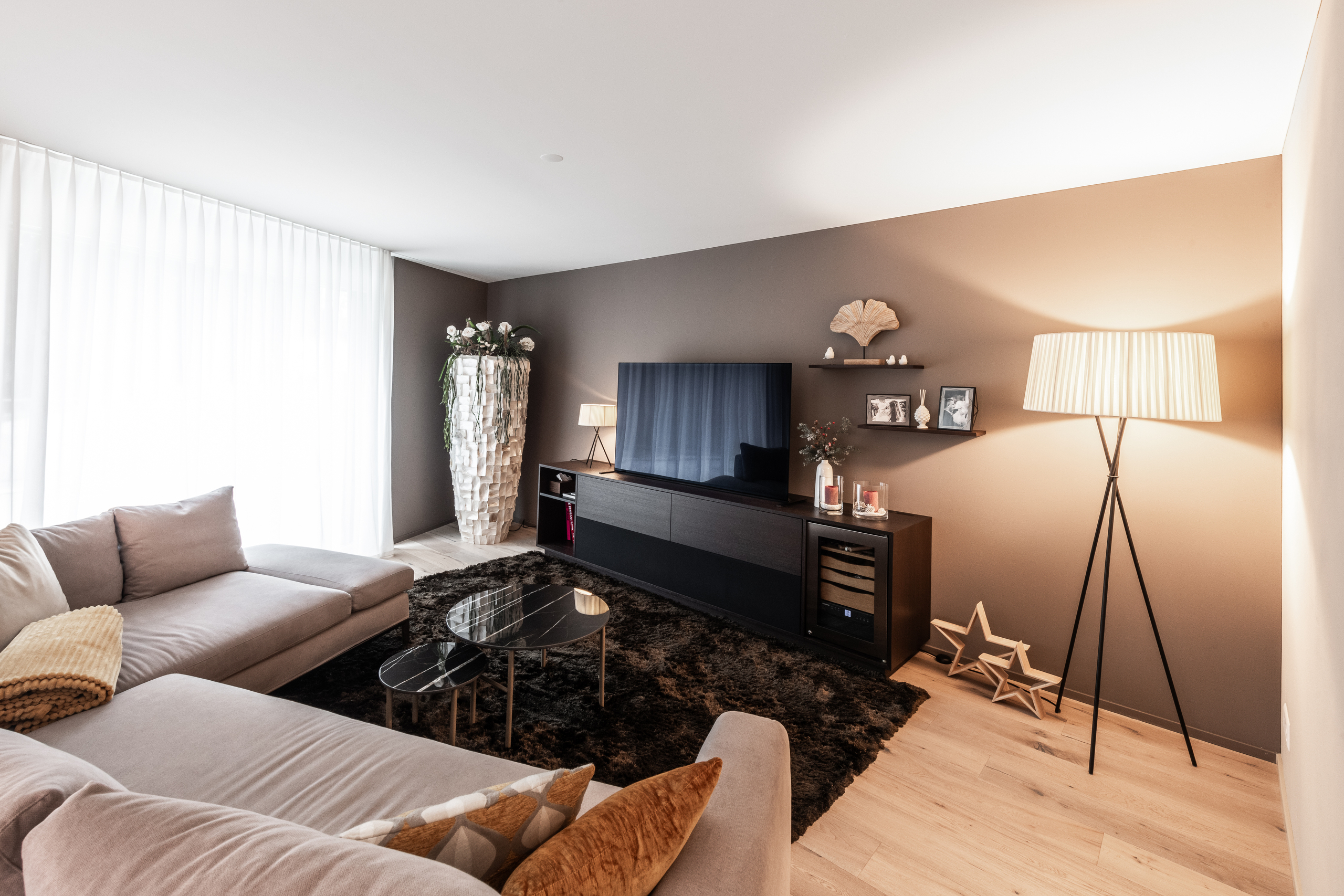 Modernes Wohnzimmer mit großer Fensterfront und TV-Wand