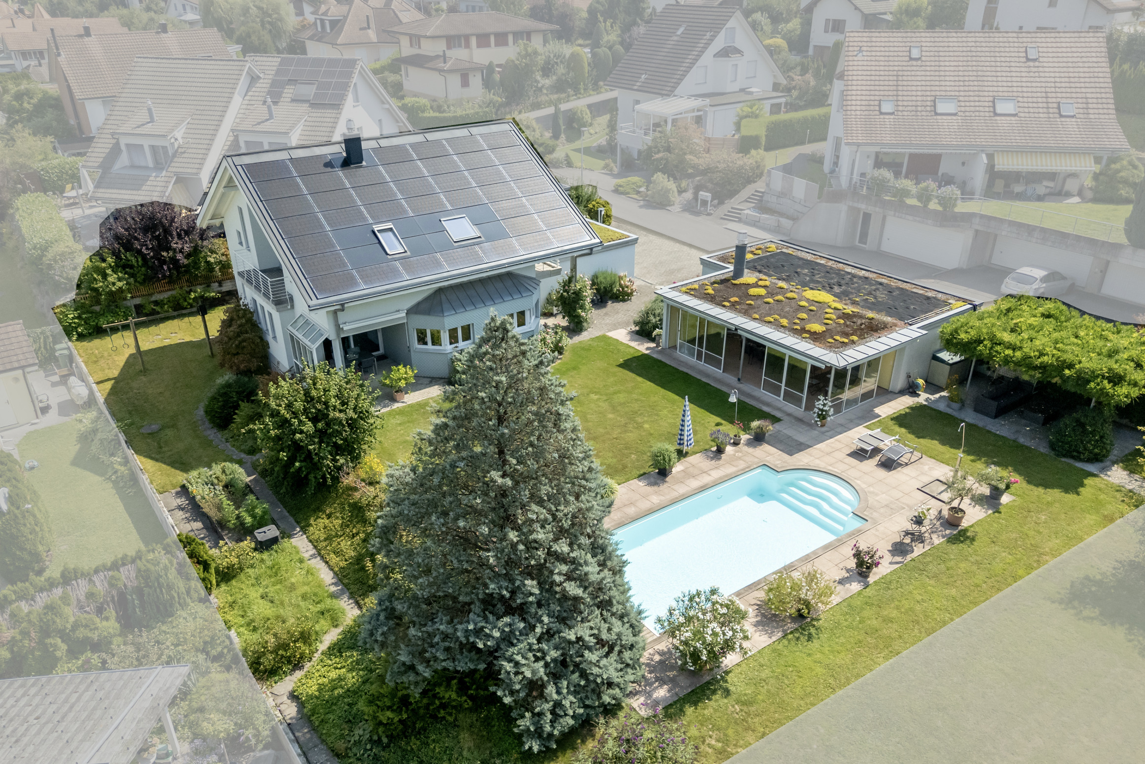 Luftaufnahme eines Einfamilienhauses mit großem Garten und Pool