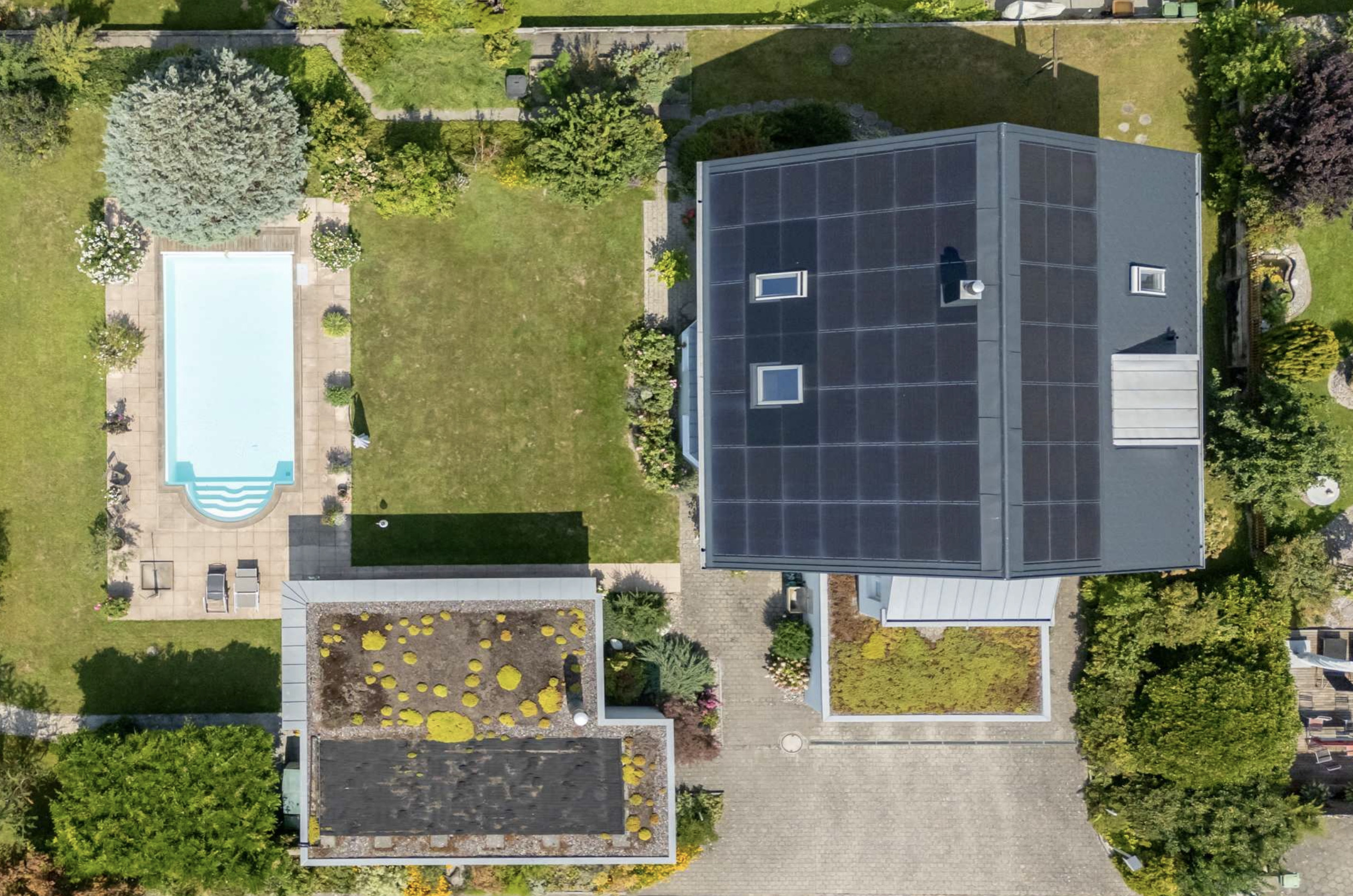 Luftaufnahme eines Grundstücks mit Pool und Solardach