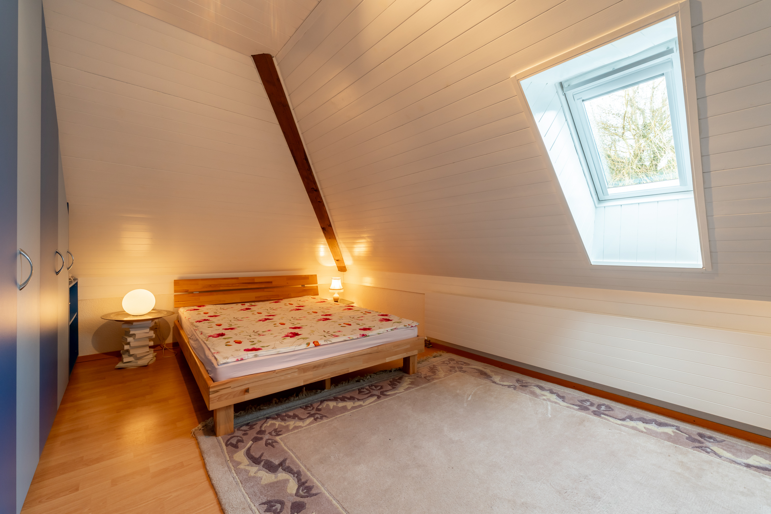 Dachgeschoss-Schlafzimmer mit Holzbett
