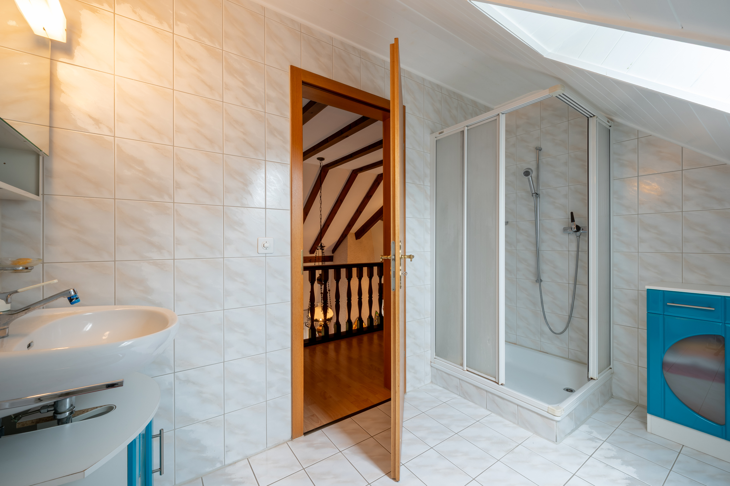 Dachgeschoss-Badezimmer mit Dusche und Waschbecken