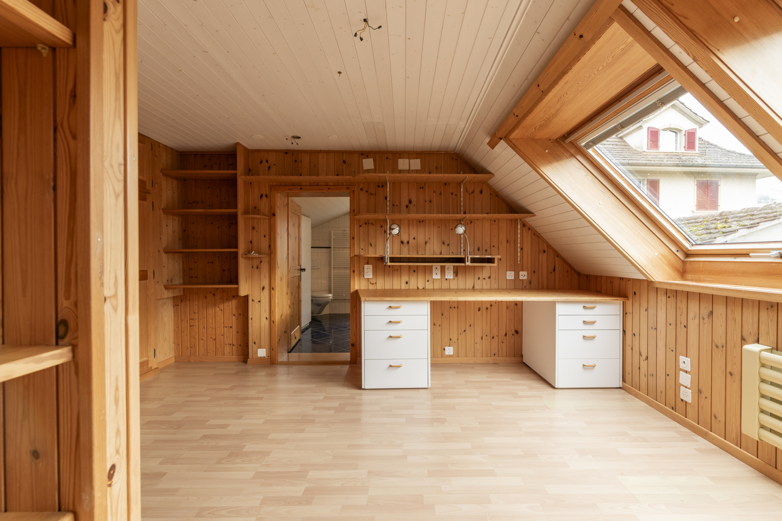 Dachzimmer mit Holzvertäfelung und Dachfenster