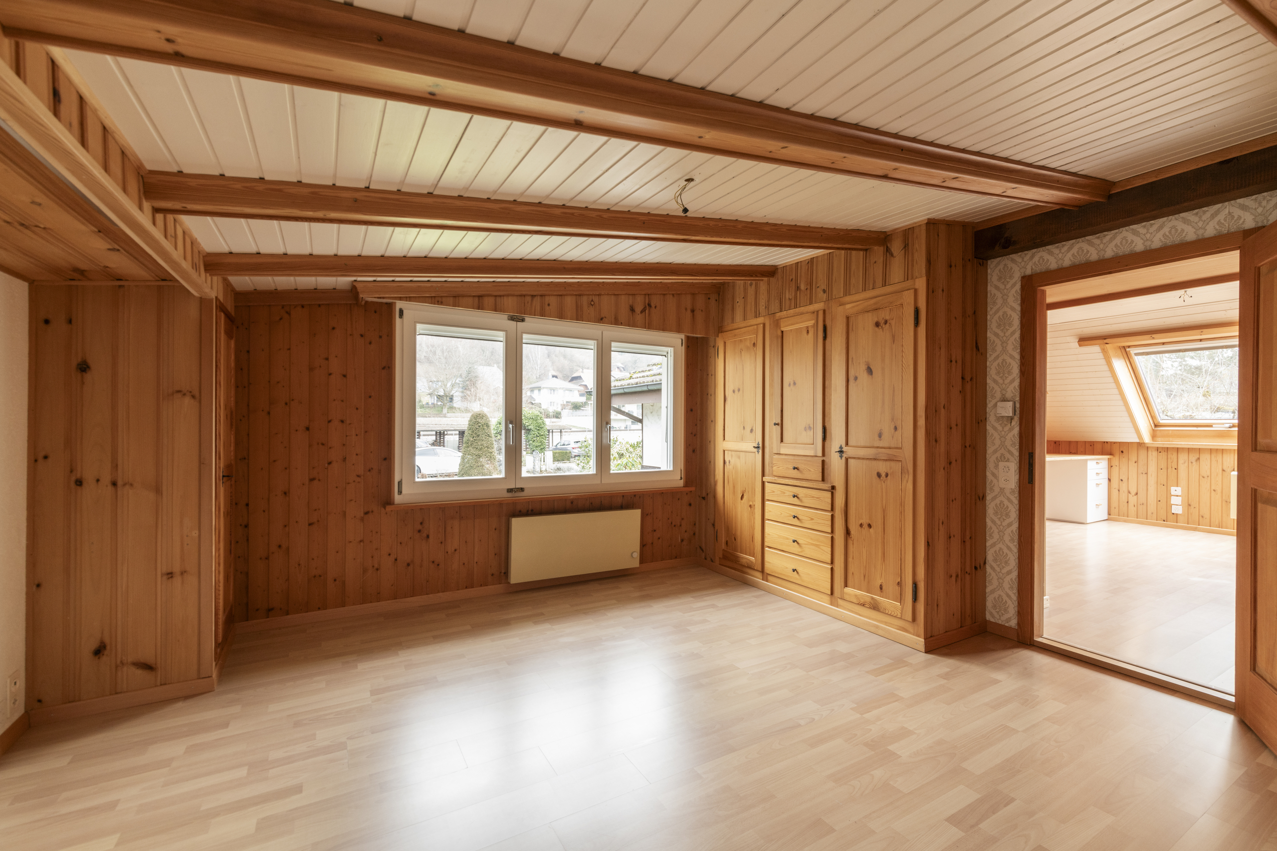 Helles, holzvertäfeltes Zimmer mit Dachschrägencharakter
