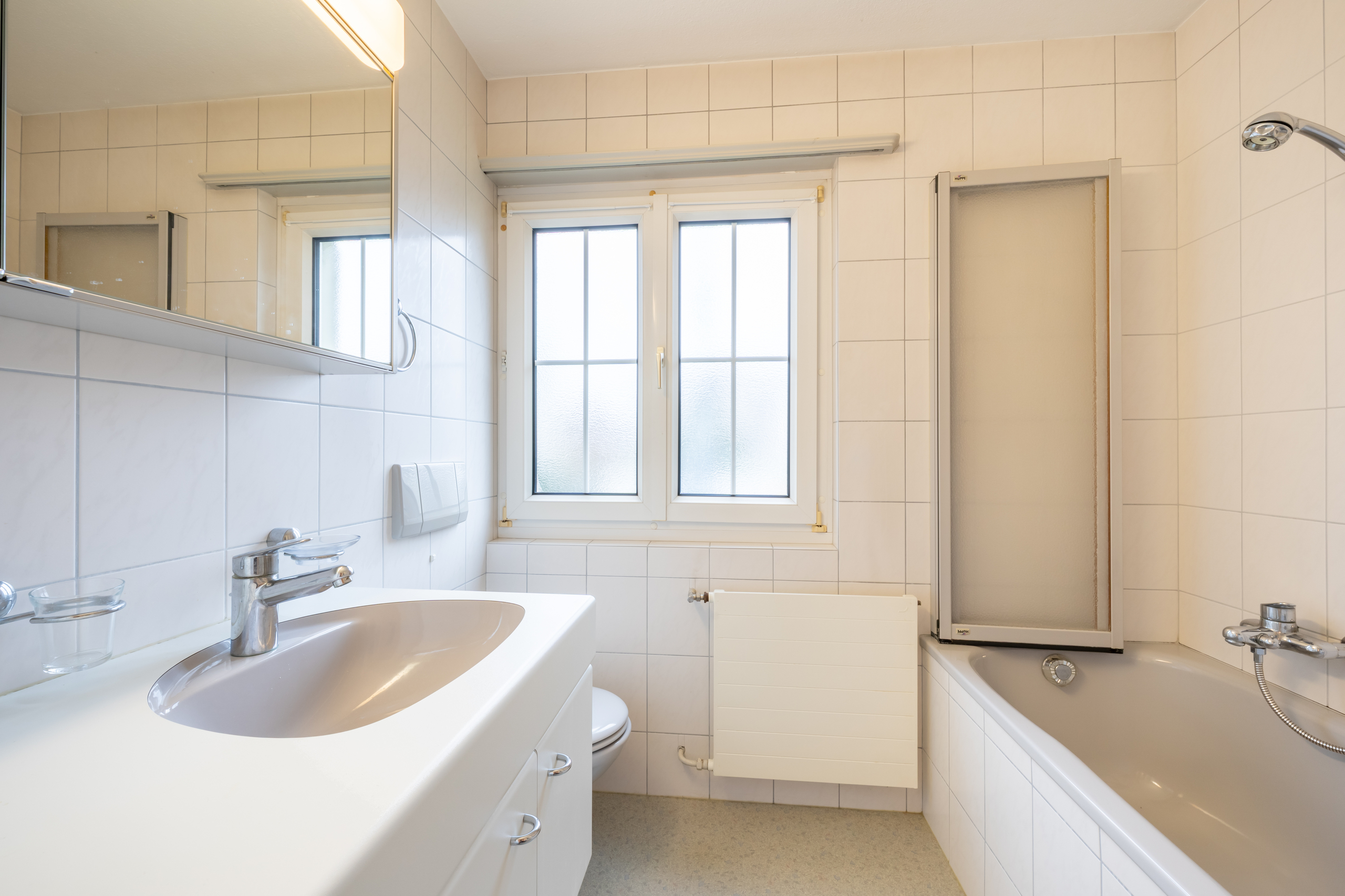 Helles Badezimmer mit Wanne und Fenster