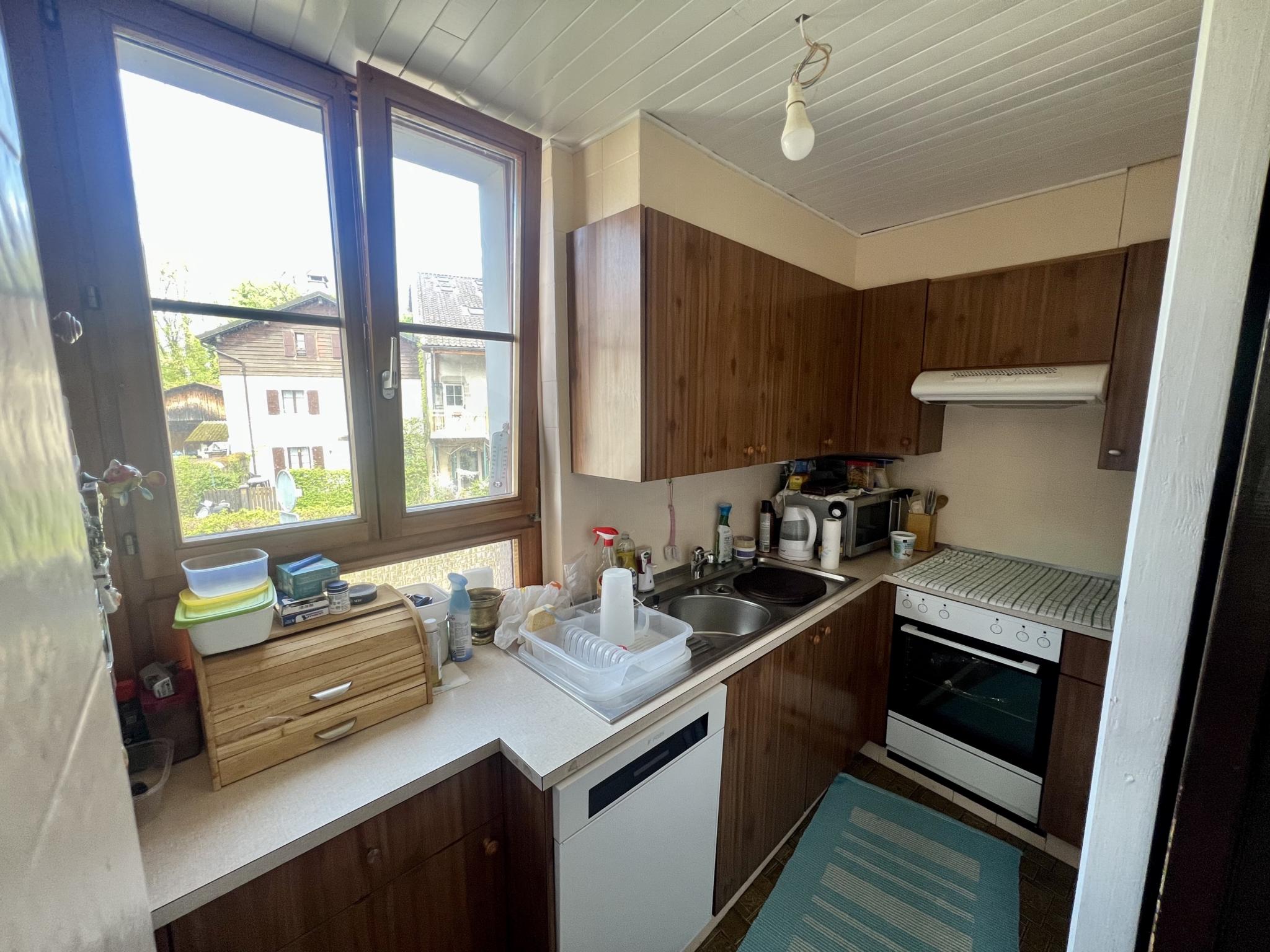 Kleine Küche mit Holzoptik und Fensterblick
