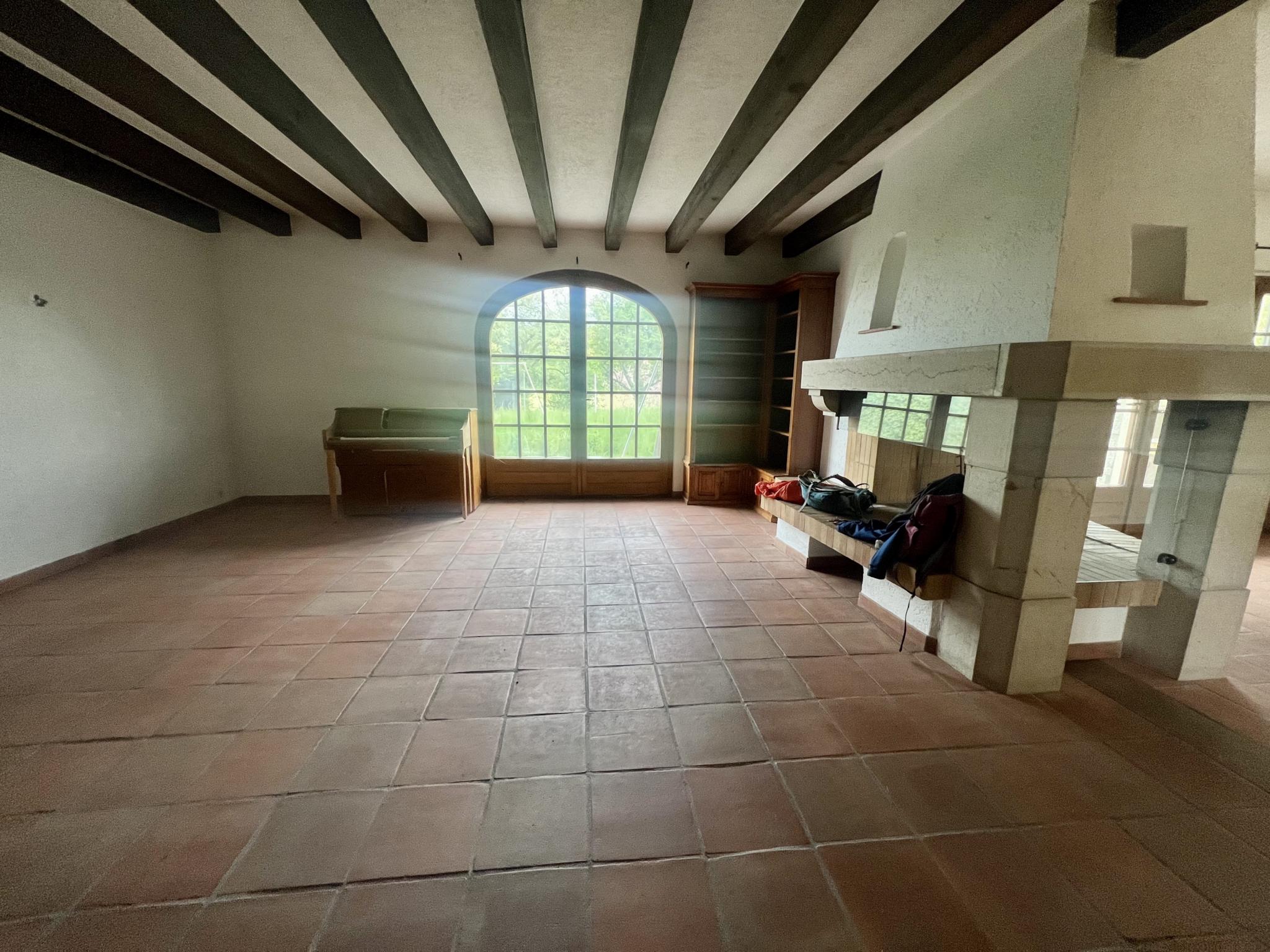 Großer Raum mit Kamin und Rundbogenfenster
