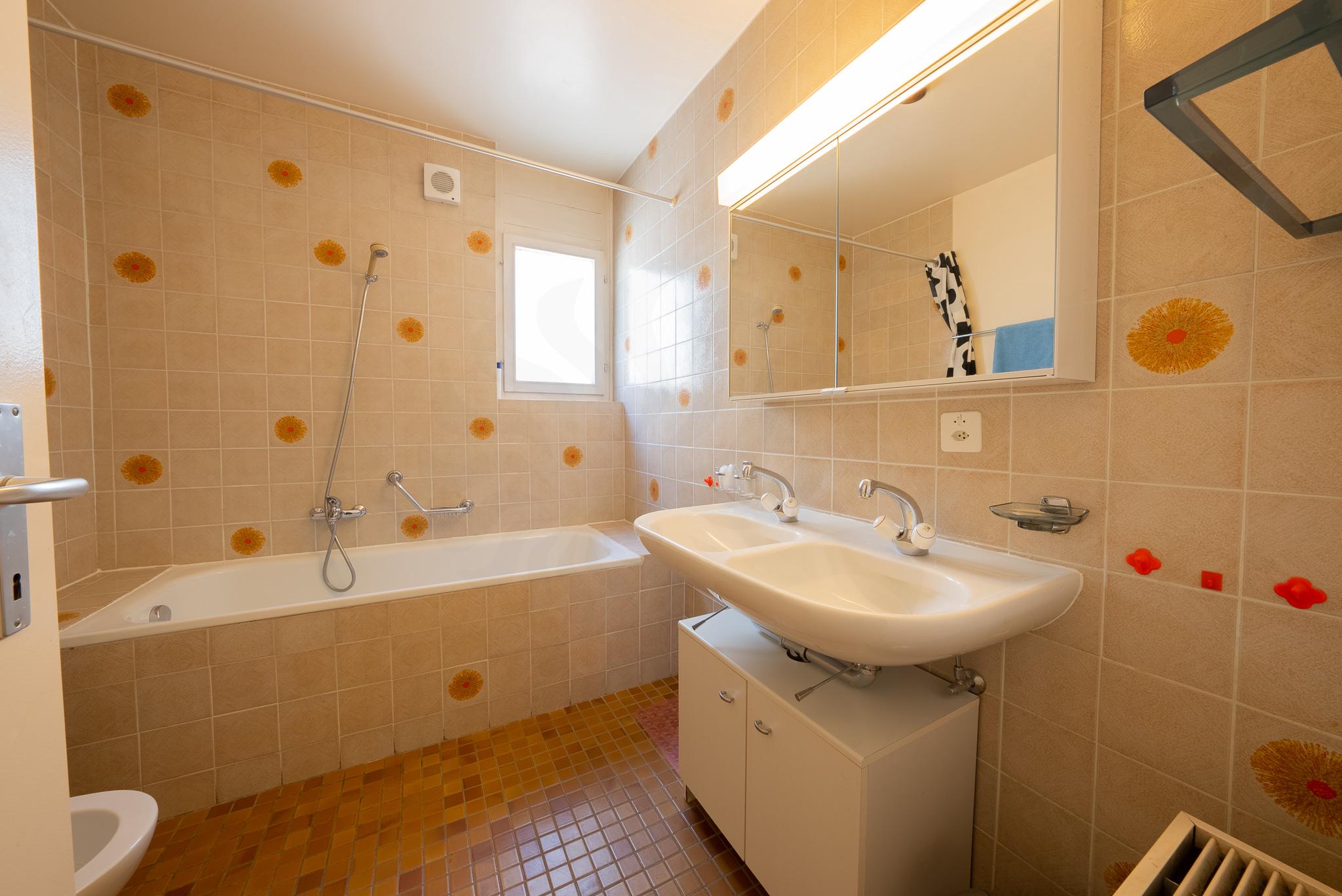 Badezimmer mit Badewanne und Waschtisch